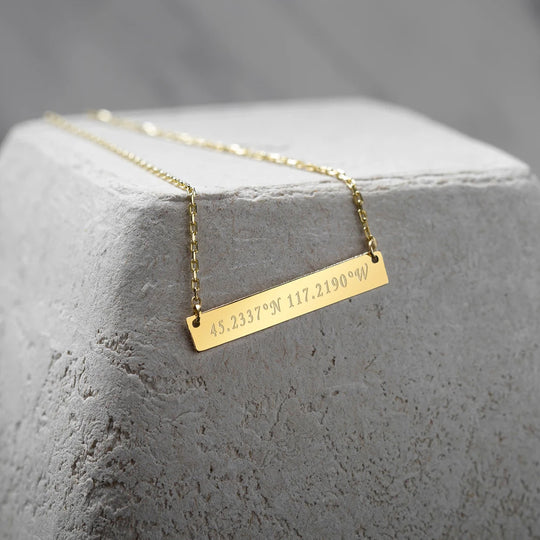 Diseño minimalista de collar con barra grabada.