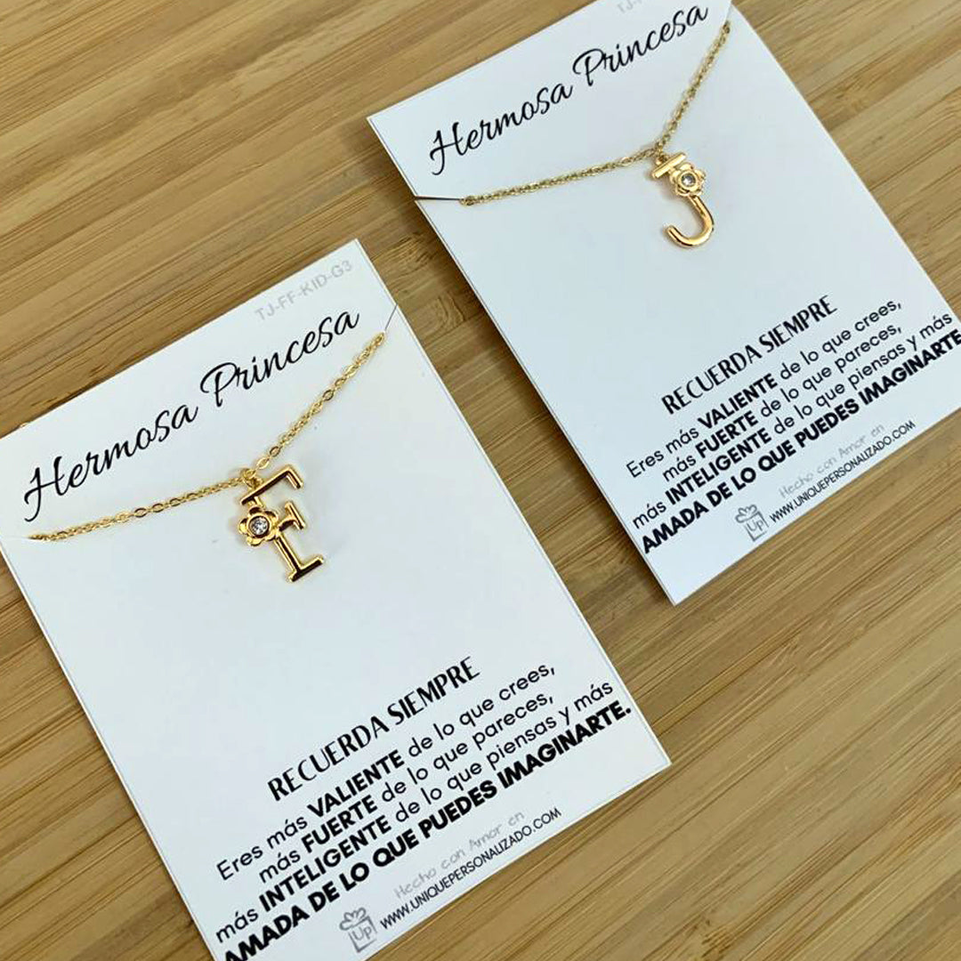 Dije con letra personalizada, flor en detalle y circonia brillante que refleja elegancia en cada ángulo.