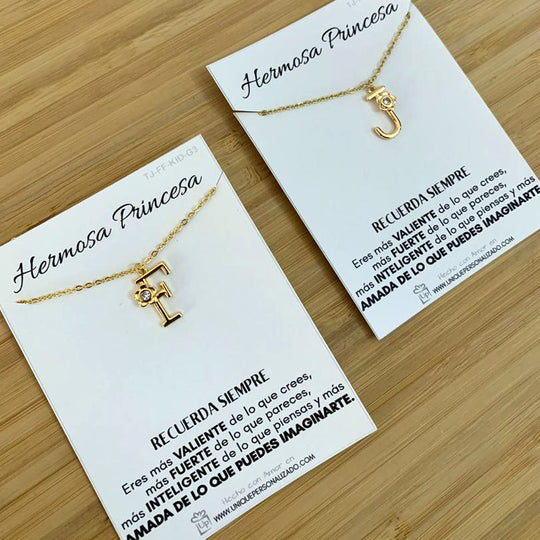 Dije con letra personalizada, flor en detalle y circonia brillante que refleja elegancia en cada ángulo.